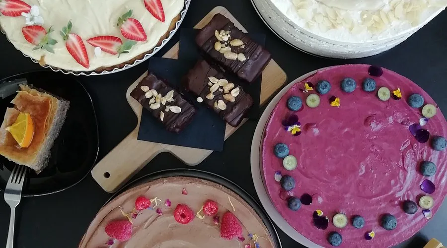 Selection of artisanal vegan cakes and pastries on display at the Tavči Kuhna counter in Lesce